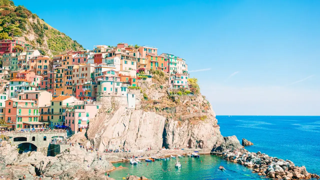Case colorate aggrappate alla scogliera, un incantevole levante città sul mare blu.
