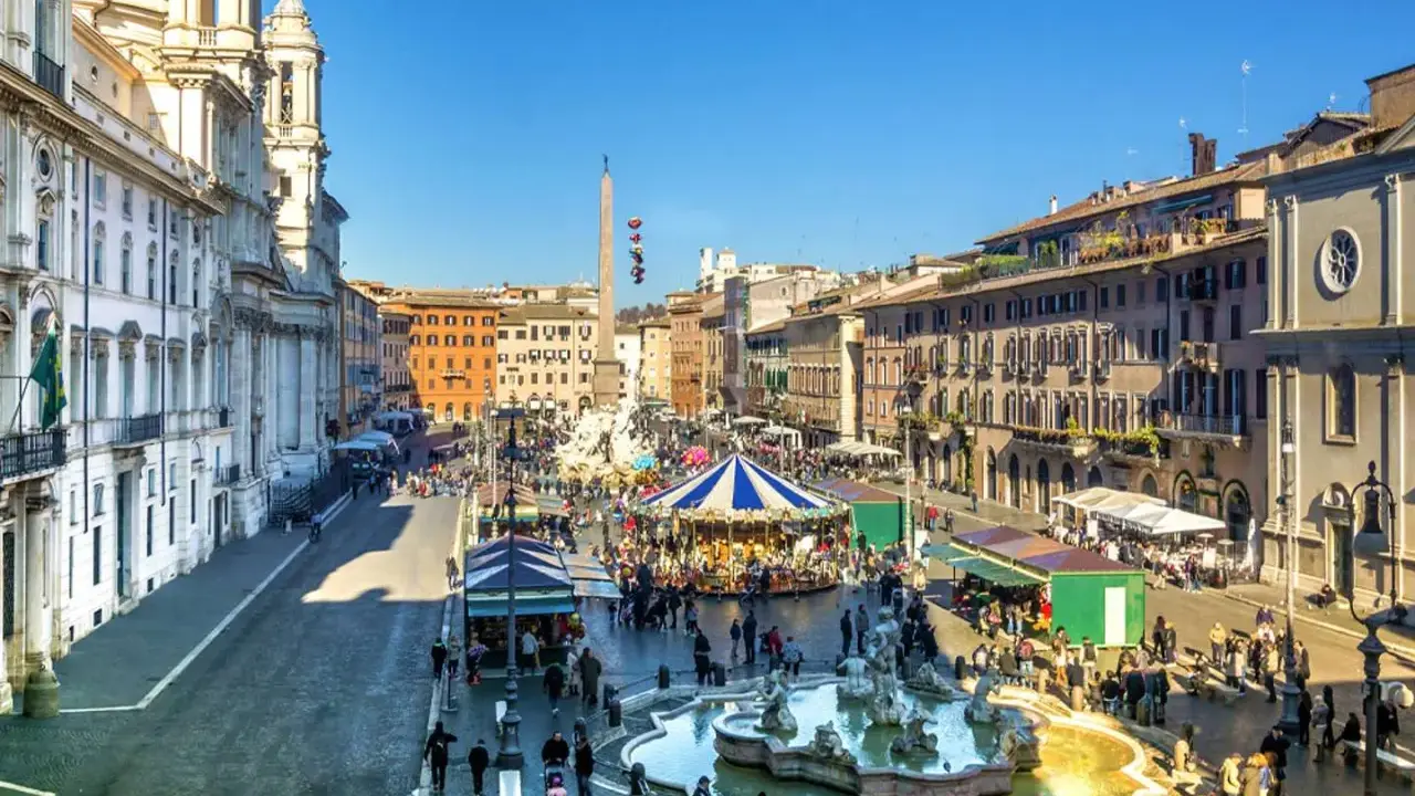 Piazza Navona a Roma a dicembre, con giostra, fontana e bancarelle.
