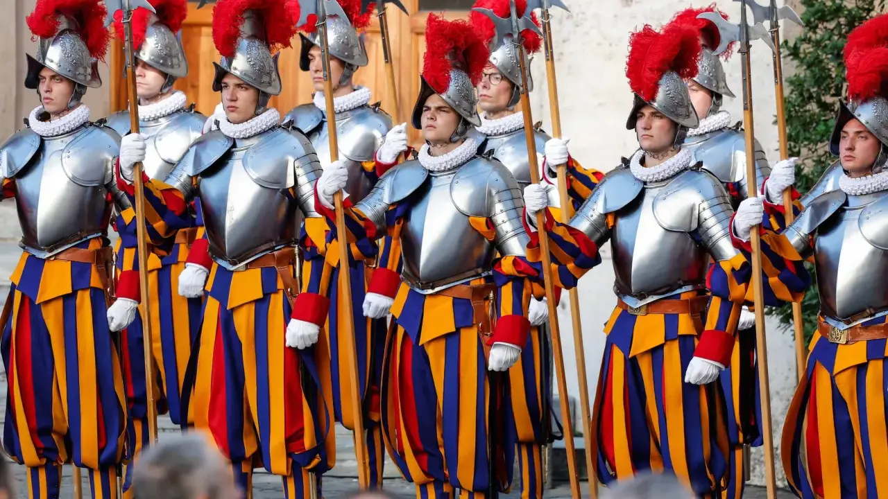 Guardie svizzere in divisa storica, con elmi piumati e alabarde, pronti a difendere la Città del Vaticano.