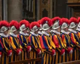 Guardie svizzere in divisa colorata, con elmi piumati, spiegano perchè il Papa ha le guardie svizzere: sono la sua protezione storica.