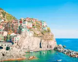 Case colorate aggrappate alla scogliera, un incantevole levante città sul mare blu.