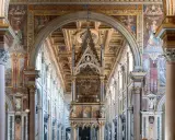 Interno di San Giovanni in Laterano: maestoso baldacchino, affreschi dorati e colonne imponenti creano un'atmosfera sacra.