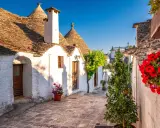 Un vicolo fiorito tra i trulli di Alberobello, un'idea perfetta per sapere dove andare in primavera.