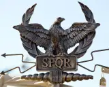 Aquila romana con SPQR, simbolo di Roma, con ali spiegate e frecce.