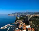 Vista panoramica di Sorrento: cosa vedere a Sorrento in un giorno, con il porto, le case colorate a picco sul mare e i monti sullo sfondo.