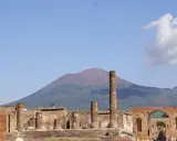 Rovine di Pompei con il Vesuvio sullo sfondo. Un'idea per cosa visitare a Pompei in un giorno, tra colonne antiche e storia millenaria.