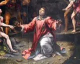 Painting of a saint in a red robe kneeling and looking up, with other figures around.
