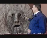 Un uomo indica la Bocca della Verità a Roma, un'antica scultura che si dice morda la mano dei bugiardi. Il suo significato è legato alla giustizia e alla verità.