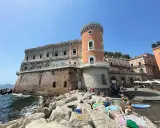 Un perfetto week end a Napoli: Castel dell'Ovo baciato dal sole, gente che prende il sole e si gode il mare.
