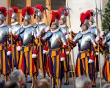 Guardie svizzere in divisa storica, con elmi piumati e alabarde, pronti a difendere la Città del Vaticano.
