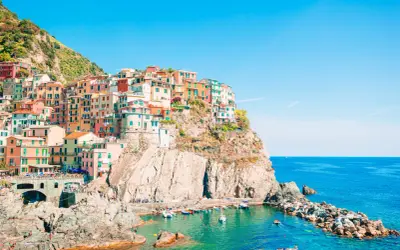 Case colorate aggrappate alla scogliera, un incantevole levante città sul mare blu.