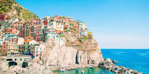 Case colorate aggrappate alla scogliera, un incantevole levante città sul mare blu.