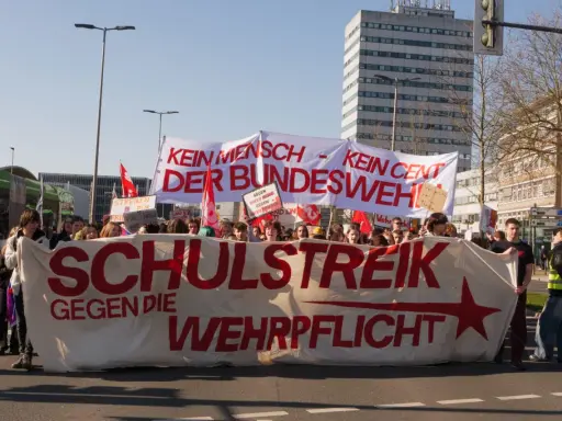Giovani in protesta con uno striscione "Scuola contro la leva obbligatoria". Una vera lotta senza quartiere per la pace.