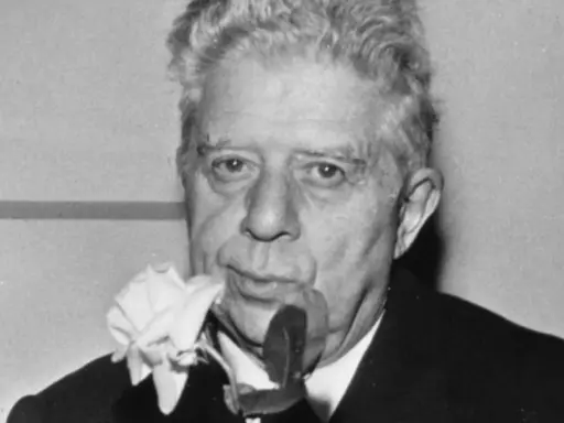 Un uomo con una rosa bianca al bavero, come se "ho sceso dandoti il braccio" fosse un ricordo dolce.