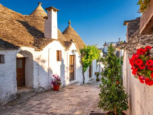 Un vicolo fiorito tra i trulli di Alberobello, un'idea perfetta per sapere dove andare in primavera.