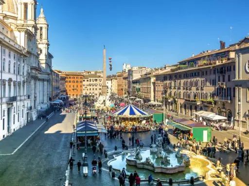 Piazza Navona a Roma a dicembre, con giostra, fontana e bancarelle.