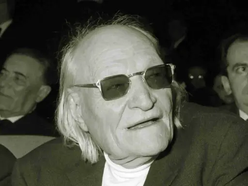Un uomo anziano con occhiali da sole, capelli lunghi e bianchi, sembra un poeta. Sono una creatura ungaretti.