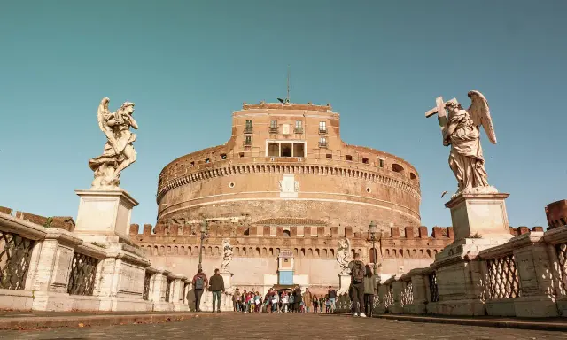 Ponte Sant'Angelo con statue di angeli e Castel Sant'Angelo, un tempo prigioni, sullo sfondo.