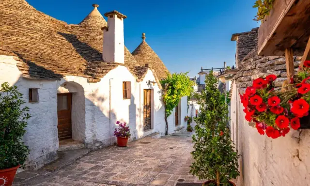 Un vicolo fiorito tra i trulli di Alberobello, un'idea perfetta per sapere dove andare in primavera.