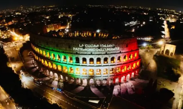 Il Colosseo illuminato di notte con i colori della bandiera italiana, celebra "La Cucina Italiana Patrimonio dell'Umanità", un riconoscimento che il Colosseo, patrimonio dell'UNESCO, merita.