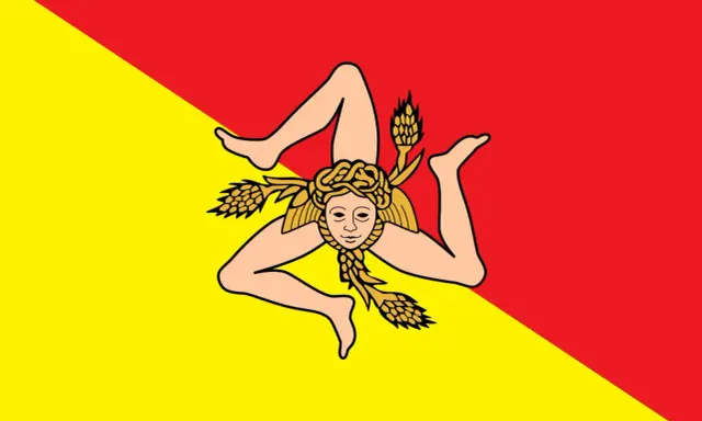 Lo stemma della Sicilia, la Trinacria, con la testa di Medusa e tre spighe di grano, su sfondo diviso in giallo e rosso.
