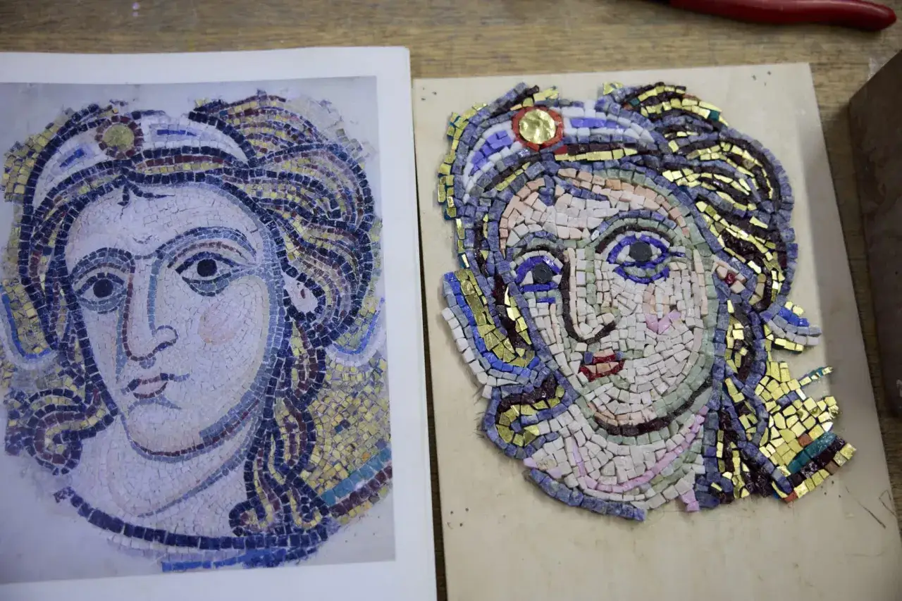 Ricostruzione di famosi mosaici romani: un volto femminile in tessere colorate, accanto all'originale su carta.