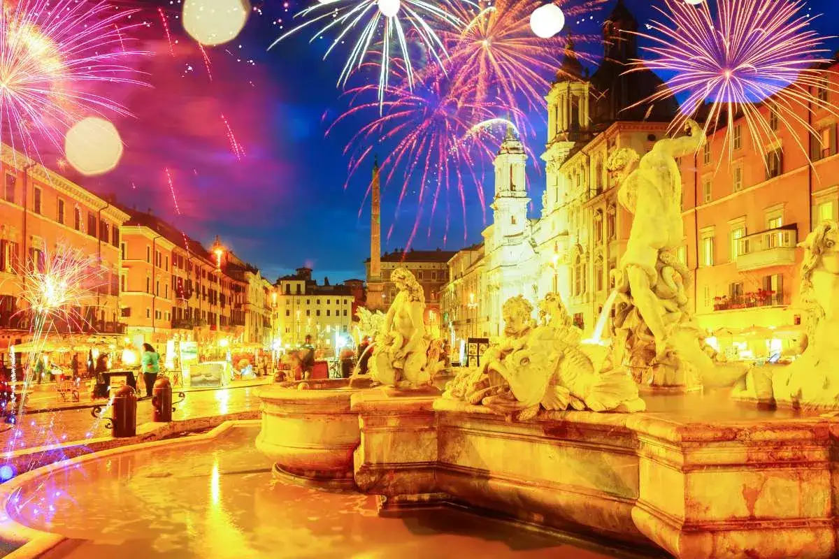 Fuochi d'artificio illuminano Piazza Navona, un'idea su cosa vedere a Roma a Natale. Fontane barocche e palazzi storici brillano sotto il cielo notturno.