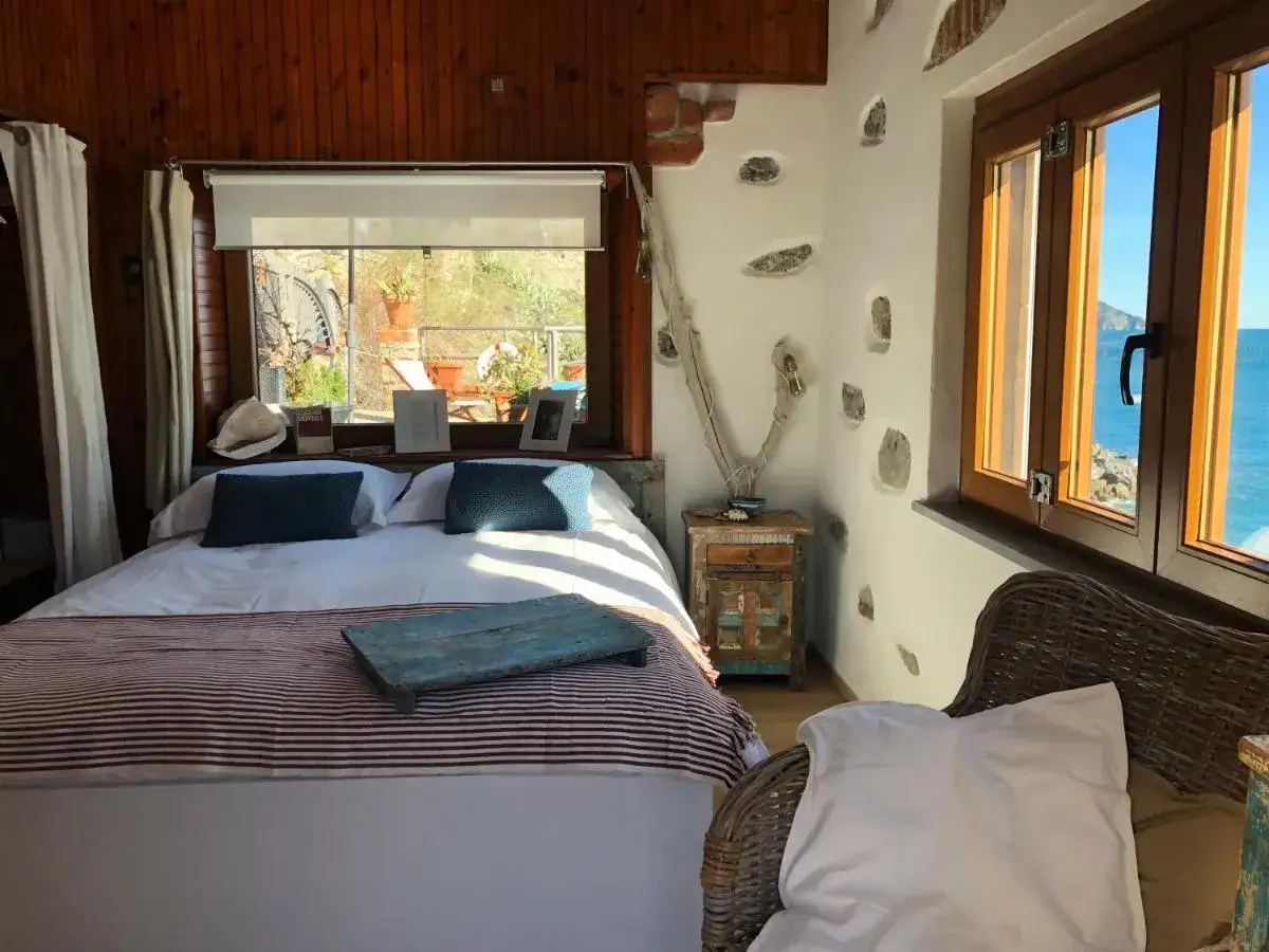 Interno accogliente con letto, vista mare e dettagli rustici. Un angolo de