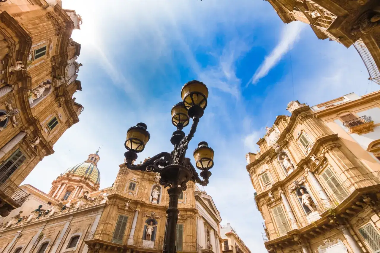Un lampione antico domina la scena, incorniciato da palazzi barocchi e una cupola verde. Un assaggio di cosa vedere a Palermo, tra storia e bellezza.
