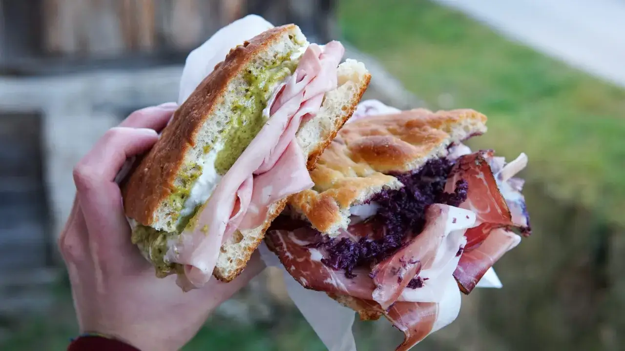 Due panini con focaccia, uno con mortadella e pesto, l'altro con salumi e cavolo rosso. Un vero pan per focaccia significato di gusto.