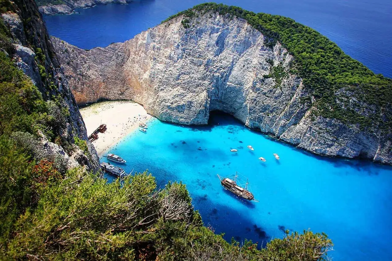 Navagio, Zacinto: analisi e commento scuola media. Spiaggia bianca, acque turchesi, scogliere imponenti e un relitto.