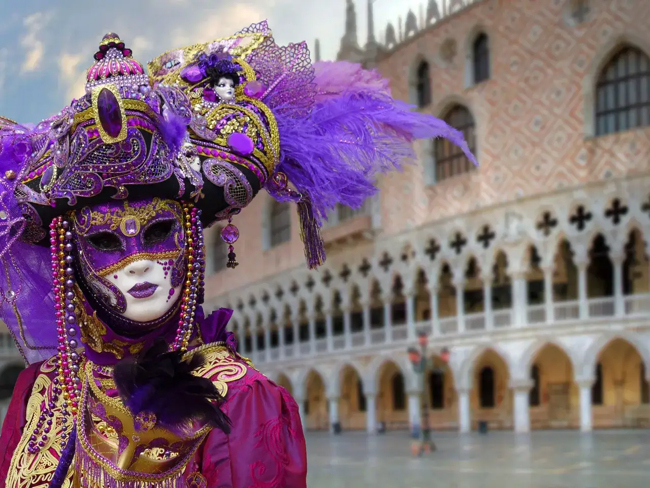 Maschera elaborata e colorata, simbolo dei carnevali famosi in Italia, con sfondo sfocato di un palazzo veneziano.