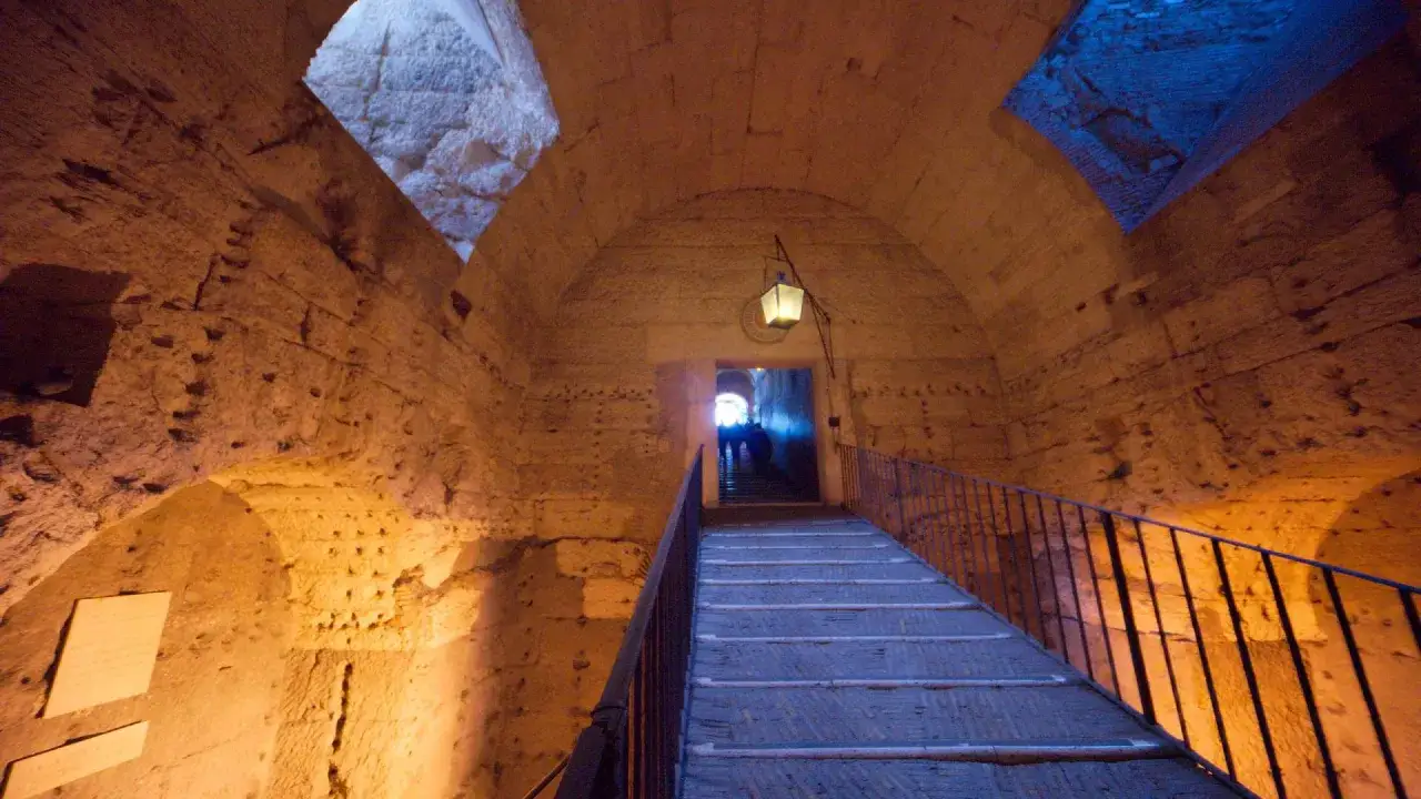 Interno di Castel Sant'Angelo, una scala conduce verso l'oscurità, evocando le antiche prigioni.