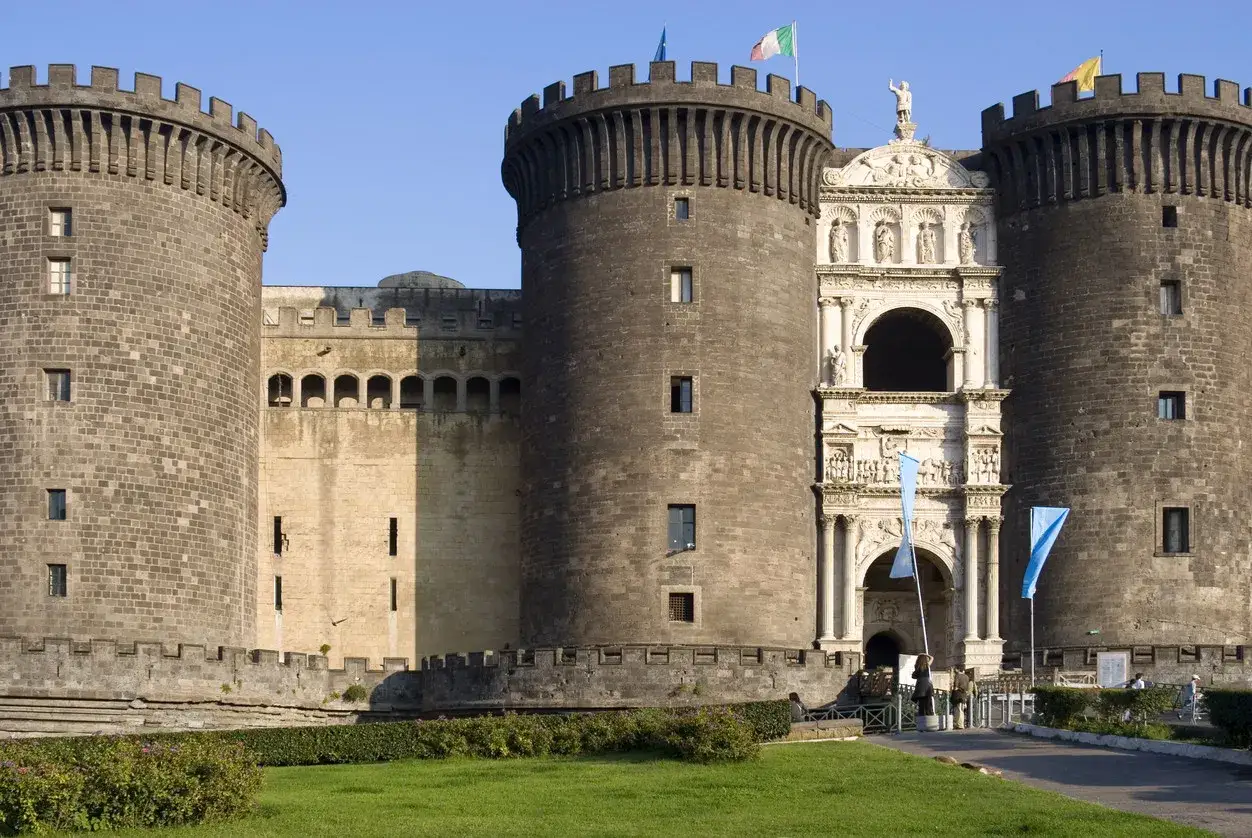 Il maestoso Maschio Angioino, con le sue torri imponenti e l'arco trionfale, domina il paesaggio napoletano.