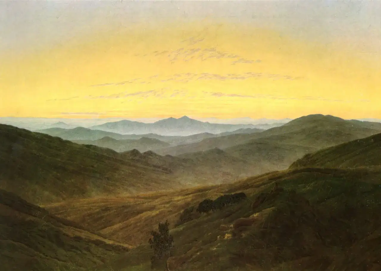 Vaste colline verdi sotto un cielo giallo dorato. Un paesaggio che evoca il sentimento: 