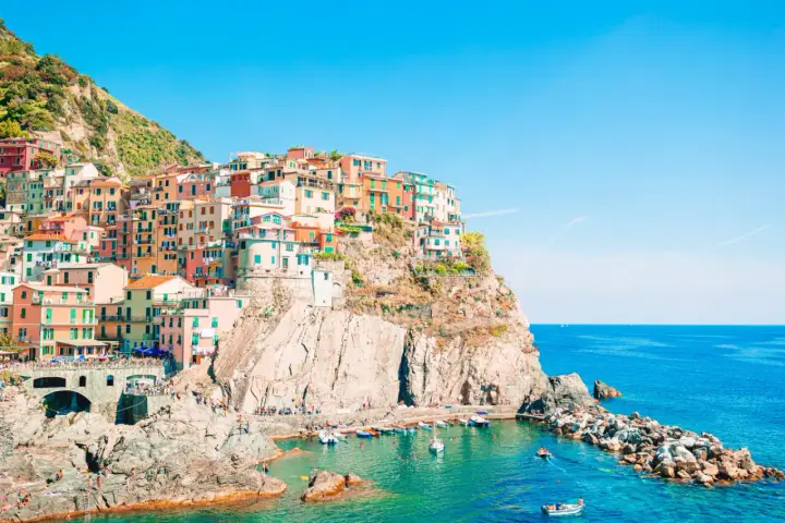 Case colorate aggrappate alla scogliera, un incantevole levante città sul mare blu.